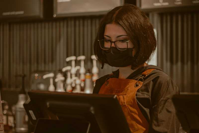 Imagem Ilustrativa - Mulher de uniforme, trabalhando em um caixa