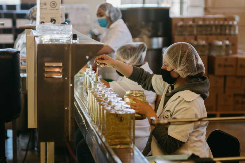 pessoas trabalhando numa linha de produção de uma empresa